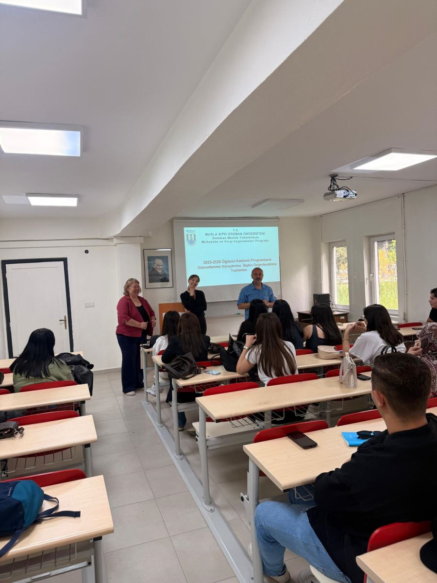 2 kadın bir erkek öğretim elemanı tahtada ve ayakta öğrenciler ile gülümseyerek sohbet ediyor.
